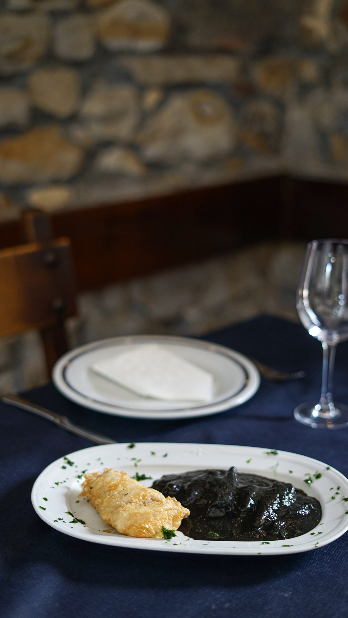 Bacalao rebozado con chipirones en su tinta, plato de cocina vasca en Bidebieta Jatetxea