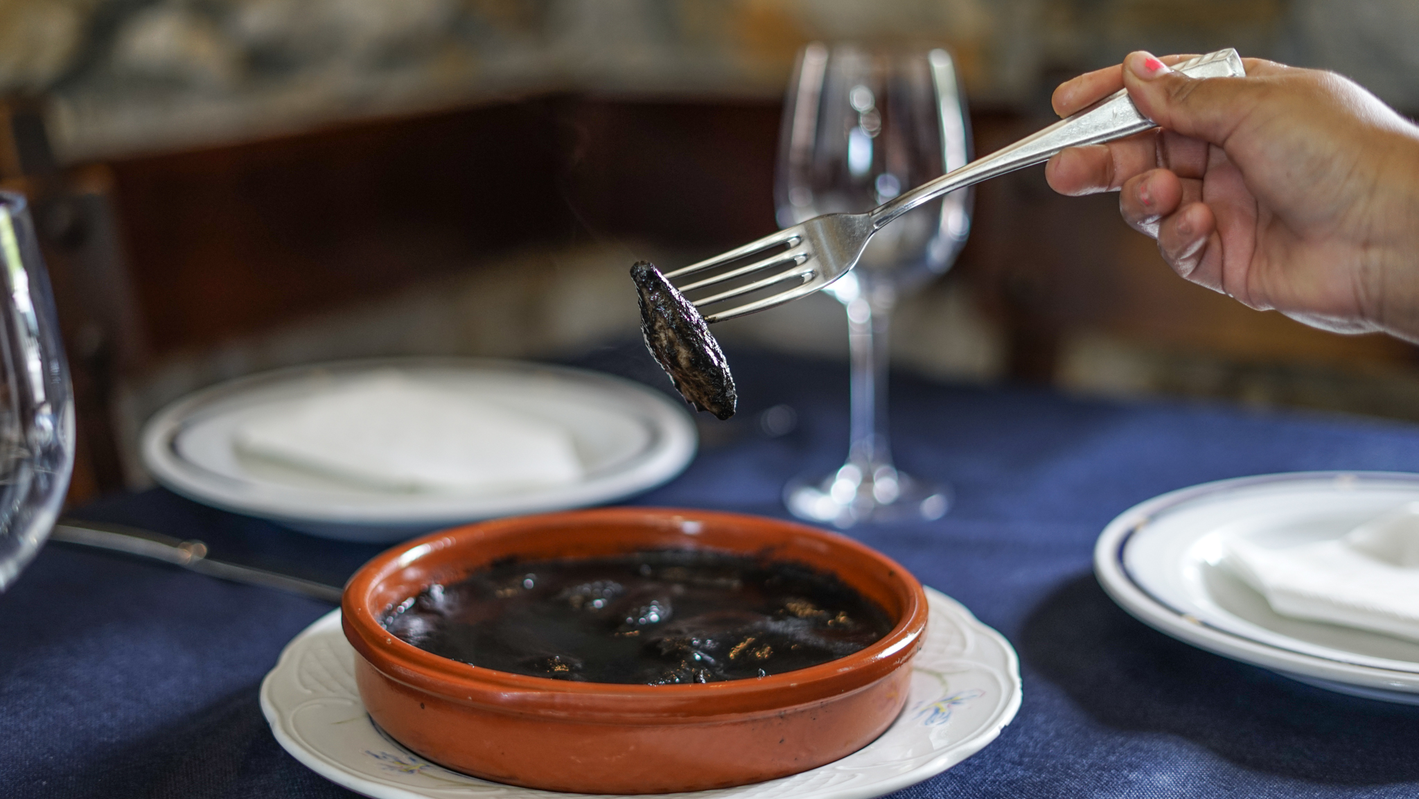 Chipirones en su tinta en cazuela de barro, plato tradicional vasco en Bidebieta Jatetxea