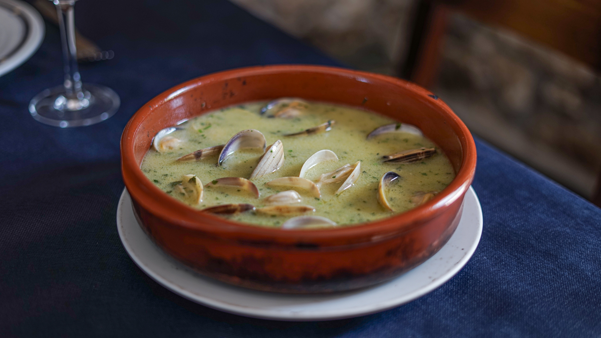 Almejas en salsa verde en cazuela de barro, cocina vasca tradicional en Bidebieta Jatetxea
